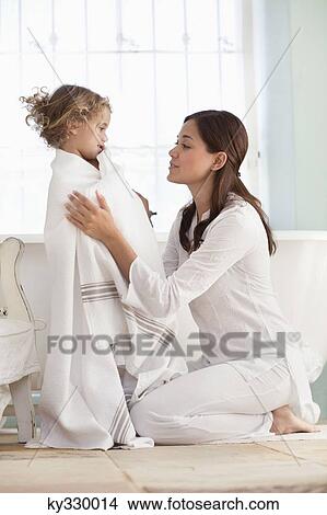 Woman wrapping her daughter in towel after the bath View Large Photo Image Picture - Woman wrapping her daughter in towel after the bath. Fotosearch