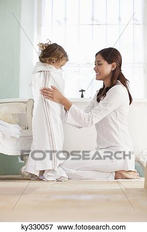Woman wrapping her daughter in towel after the bath View Large Photo Image Stock Photo - Woman wrapping her daughter in towel after the bath. Fotosearch