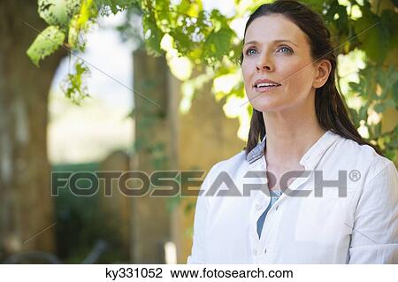 Stock Image - Beautiful mature woman day dreaming. Fotosearch