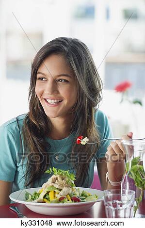 Beautiful woman eating food in a restaurant View Large Photo Image Stock Photo - Beautiful woman eating food in a restaurant. Fotosearch