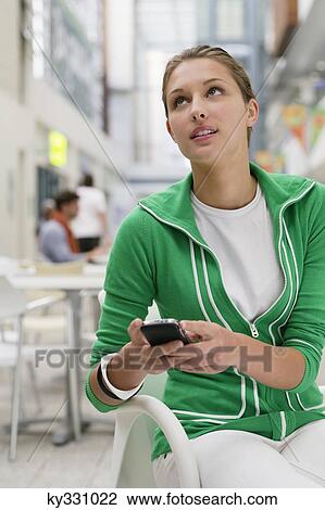 Beautiful woman using mobile phone in university lobby View Large Photo Image Stock Image - Beautiful woman using mobile phone in university lobby. Fotosearch