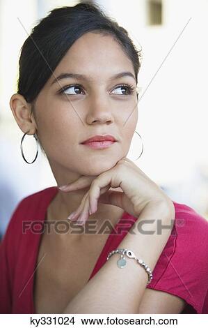 Picture - Contemplative woman looking away with hand on chin. Fotosearch