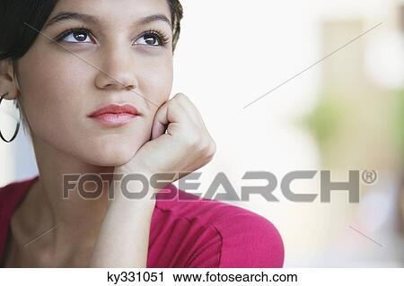 Contemplative woman looking away with hand on chin View Large Photo Image Stock Image - Contemplative woman looking away with hand on chin. Fotosearch