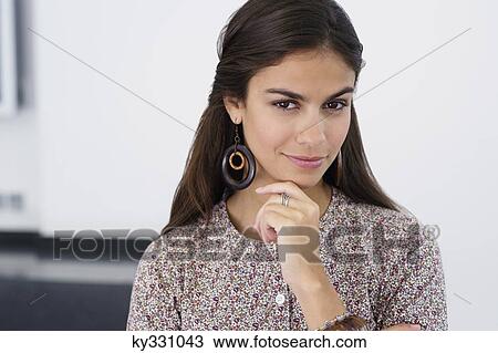 Stock Image - Portrait of a beautiful woman with hand on chin. Fotosearch