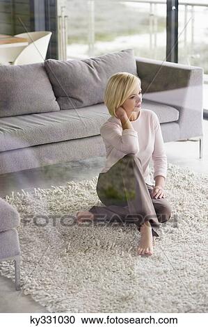 Young woman sitting on a rug and thinking View Large Photo Image Stock Image - Young woman sitting on a rug and thinking. Fotosearch