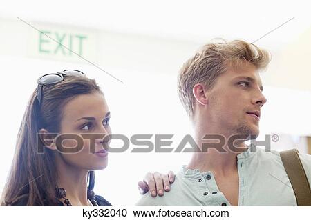 Close-up of a young couple looking away View Large Photo Image Stock Image - Close-up of a young couple looking away. Fotosearch
