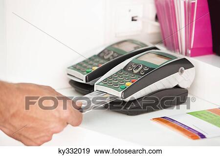 Stock Photo - Sales clerk inserting a credit card in a credit card reader. Fotosearch