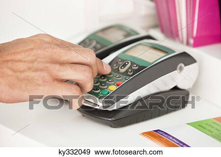 Sales clerk using a credit card reader at counter View Large Photo Image Stock Photo - Sales clerk using a credit card reader at counter. Fotosearch