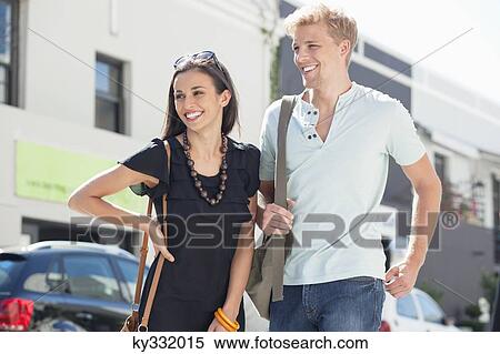 Smiling young couple standing on a street View Large Photo Image Stock Photography - Smiling young couple standing on a street. Fotosearch