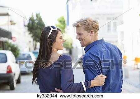Young couple looking at each other and smiling View Large Photo Image Picture - Young couple looking at each other and smiling. Fotosearch