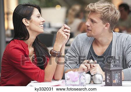 Young couple sitting in a restaurant View Large Photo Image Stock Image - Young couple sitting in a restaurant. Fotosearch