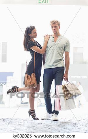 Young couple standing together with shopping bags View Large Photo Image Stock Photography - Young couple standing together with shopping bags. Fotosearch