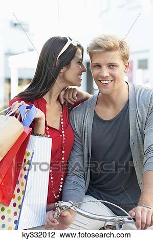 Young man on bicycle with his girlfriend whispering in ear View Large Photo Image Stock Image - Young man on bicycle with his girlfriend whispering in ear. Fotosearch