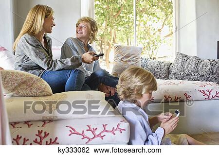 Stock Image - Children and mother using electronic gadgets at home. Fotosearch