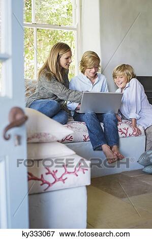 Children and their mother using laptop at house View Large Photo Image Stock Photo - Children and their mother using laptop at house. Fotosearch