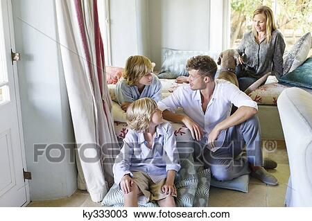 Family sitting together at house View Large Photo Image Stock Image - Family sitting together at house. Fotosearch
