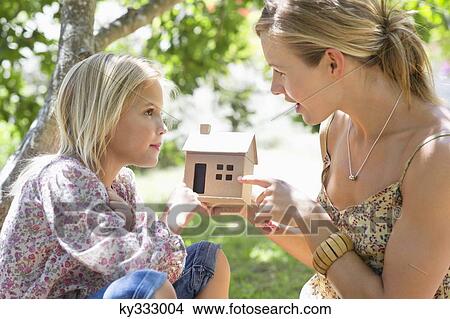Little girl and her mother holding dollhouse outdoors View Large Photo Image Picture - Little girl and her mother holding dollhouse outdoors. Fotosearch