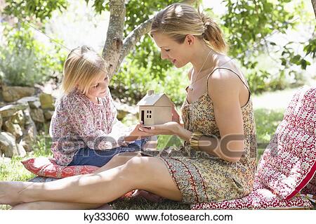 Little girl and her mother holding dollhouse outdoors View Large Photo Image Stock Image - Little girl and her mother holding dollhouse outdoors. Fotosearch