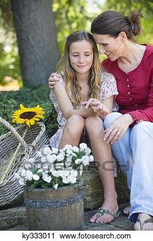 Little girl and mother sitting outdoors with flowers in the basket View Large Photo Image Stock Image - Little girl and mother sitting outdoors with flowers in the basket. Fotosearch
