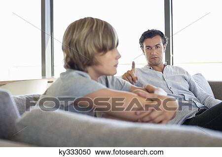 Man looking at his son looking angry View Large Photo Image Stock Image - Man looking at his son looking angry. Fotosearch