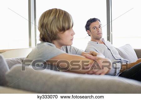 Stock Image - Man looking at his son looking angry. Fotosearch