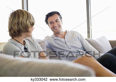 Man talking to his son and smiling View Large Photo Image Stock Image - Man talking to his son and smiling. Fotosearch