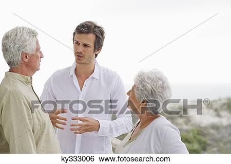 Mid adult man discussing to his parents View Large Photo Image Stock Photograph - Mid adult man discussing to his parents. Fotosearch