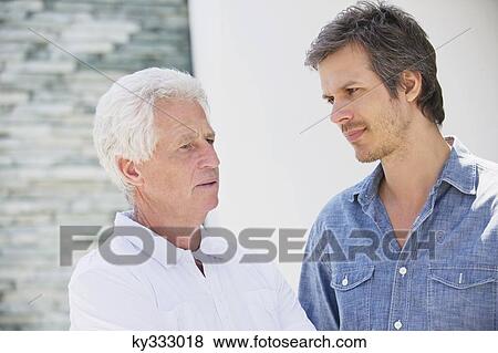 Mid adult man talking to his father View Large Photo Image Stock Photo - Mid adult man talking to his father. Fotosearch