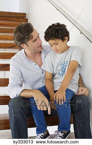 Mid adult man talking to his son View Large Photo Image Stock Image - Mid adult man talking to his son. Fotosearch
