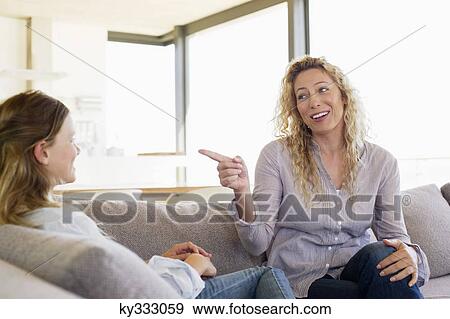 Mid adult woman pointing to her daughter and smiling View Large Photo Image Stock Photo - Mid adult woman pointing to her daughter and smiling. Fotosearch