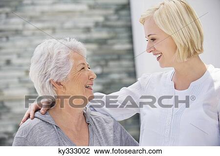 Senior woman and her daughter looking at each other and smiling View Large Photo Image Stock Image - Senior woman and her daughter looking at each other and smiling. Fotosearch