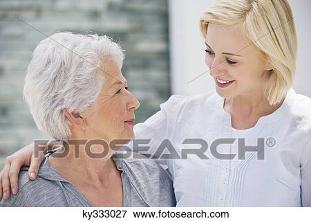 Senior woman and her daughter looking at each other and smiling View Large Photo Image Stock Photo - Senior woman and her daughter looking at each other and smiling. Fotosearch
