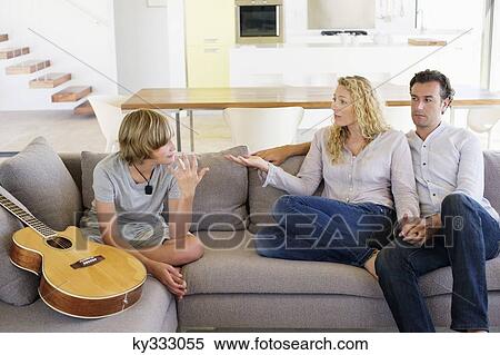 Teenage boy talking to his mother on a couch View Large Photo Image Stock Photography - Teenage boy talking to his mother on a couch. Fotosearch