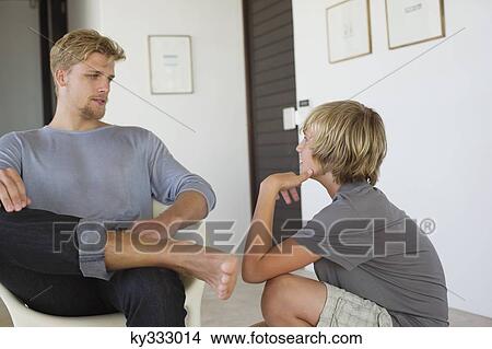 Picture - Young man talking to a teenage boy. Fotosearch