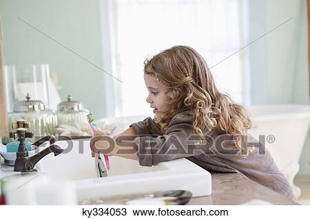 Cute little girl brushing teeth at bathroom sink View Large Photo Image Stock Image - Cute little girl brushing teeth at bathroom sink. Fotosearch