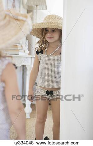 Cute little girl dressed like her mother in oversized accessories and looking at mirror View Large Photo Image Stock Photo - Cute little girl dressed like her mother in oversized accessories and looking at mirror. Fotosearch