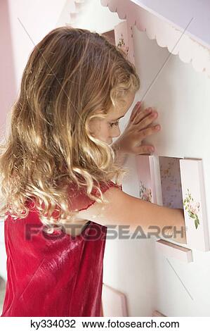 Cute little girl playing with a dollhouse View Large Photo Image Stock Image - Cute little girl playing with a dollhouse. Fotosearch