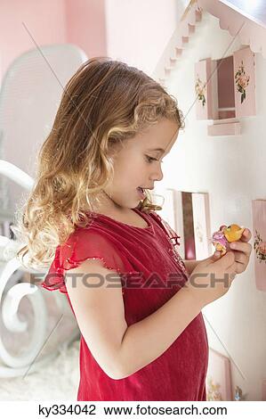 Cute little girl playing with a dollhouse View Large Photo Image Stock Image - Cute little girl playing with a dollhouse. Fotosearch
