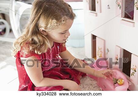 Cute little girl playing with dolls View Large Photo Image Stock Photo - Cute little girl playing with dolls. Fotosearch