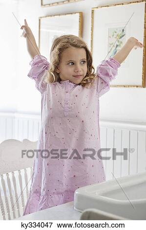Cute little girl standing with arms raised in front of a bathroom sink View Large Photo Image Stock Photo - Cute little girl standing with arms raised in front of a bathroom sink. Fotosearch