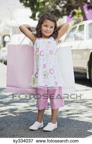 Cute little girl standing with shopping bags in hands View Large Photo Image Stock Photo - Cute little girl standing with shopping bags in hands. Fotosearch