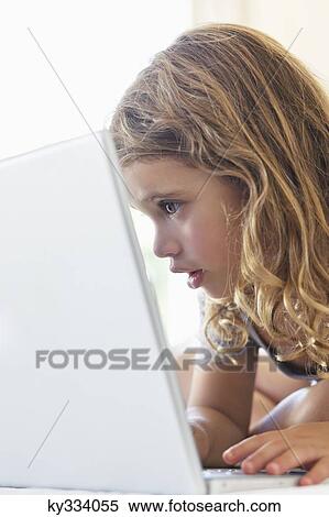 Cute little girl using a laptop in the bed View Large Photo Image Stock Photography - Cute little girl using a laptop in the bed. Fotosearch