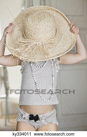 Cute little girl wearing oversized straw hat View Large Photo Image Stock Image - Cute little girl wearing oversized straw hat. Fotosearch