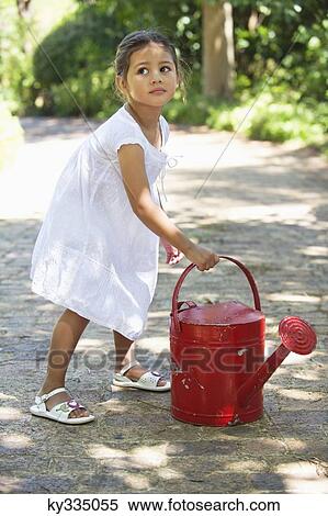 Stock Photography - Cute little girl holding a watering can. Fotosearch