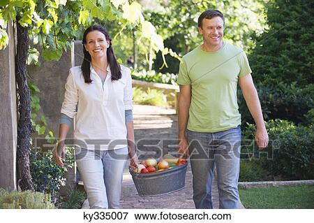 Mature couple carrying fruits basket in a garden View Large Photo Image Stock Photo - Mature couple carrying fruits basket in a garden. Fotosearch