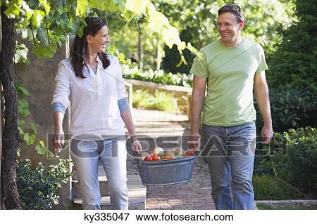 Mature couple carrying fruits basket in a garden View Large Photo Image Stock Photo - Mature couple carrying fruits basket in a garden. Fotosearch