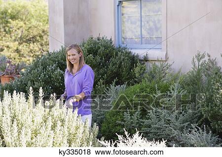 Stock Photo - Portrait of a young woman gardening. Fotosearch