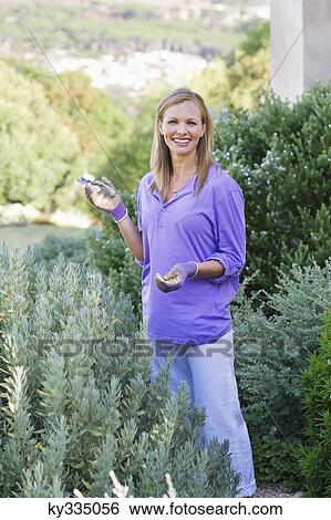 Stock Photograph - Portrait of a young woman gardening. Fotosearch