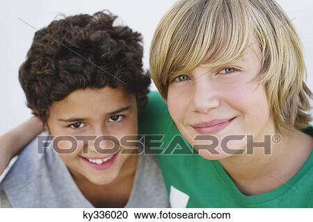 Stock Image - Close-up of a boy smiling with his brother. Fotosearch
