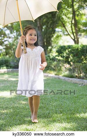 Cute little girl holding an umbrella View Large Photo Image Stock Image - Cute little girl holding an umbrella. Fotosearch